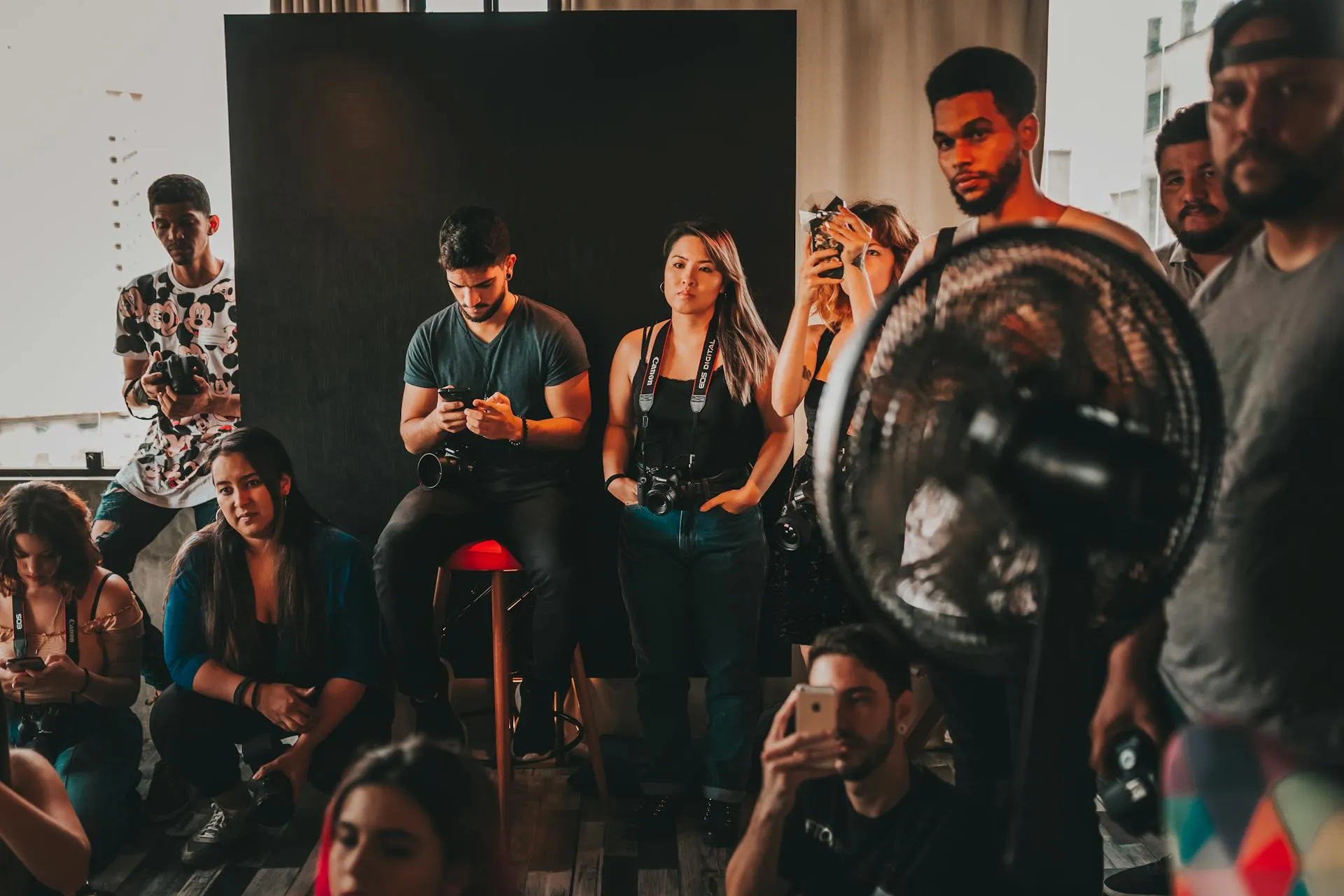A group gathered around a portrait light during a community media event