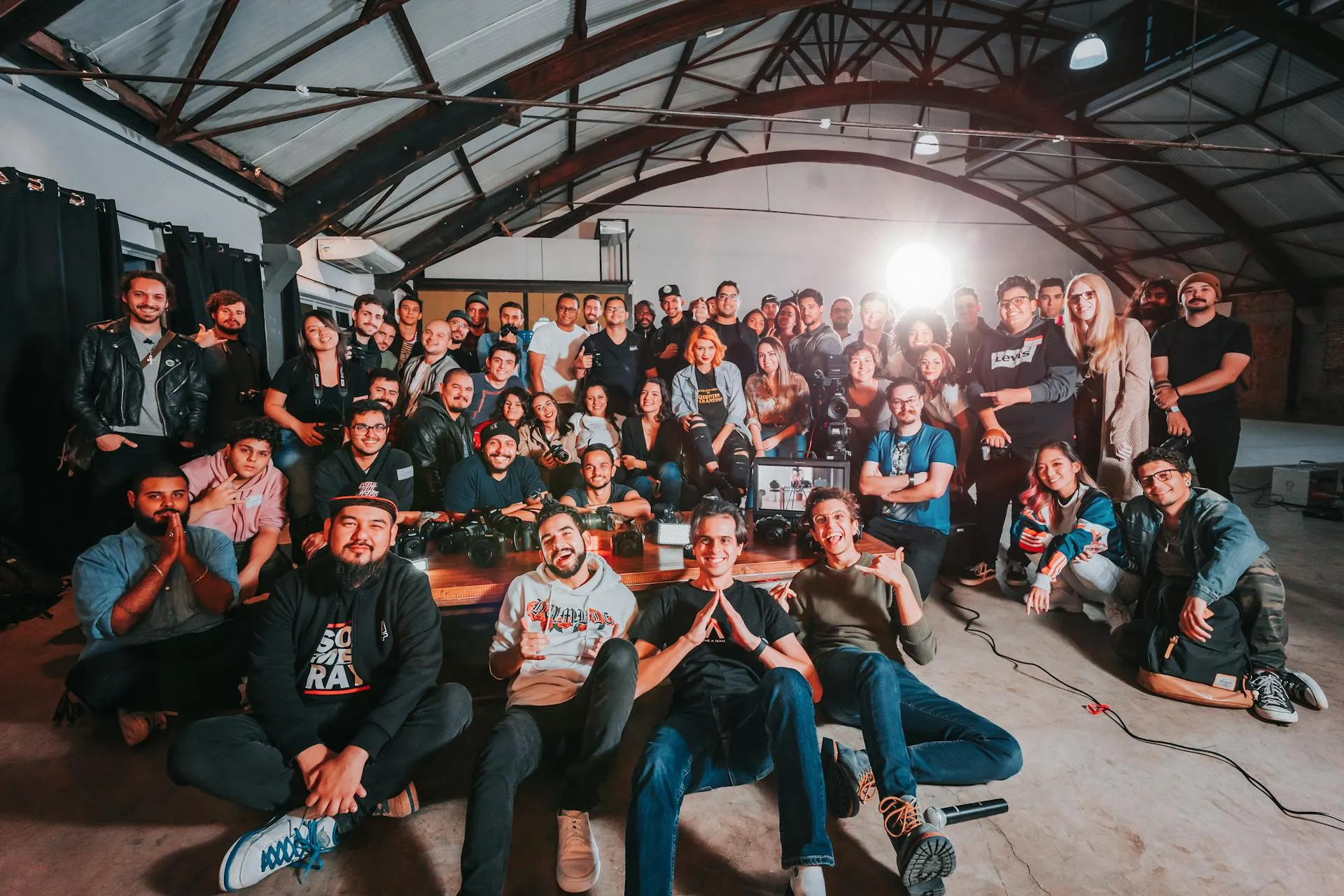 A large group posing together for a photo inside a warehouse venue