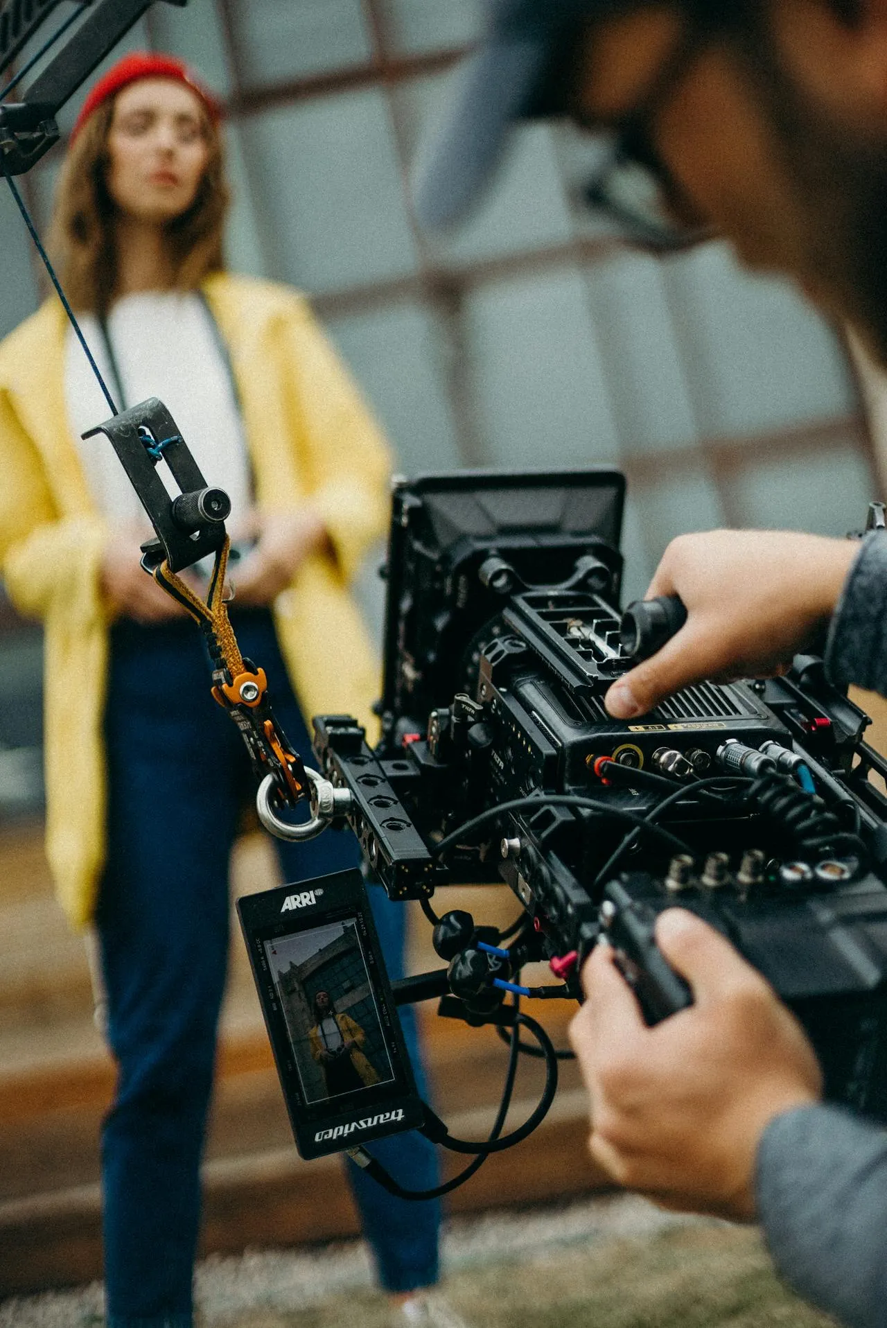 A camera operator filming a subject on an industrial-style location set