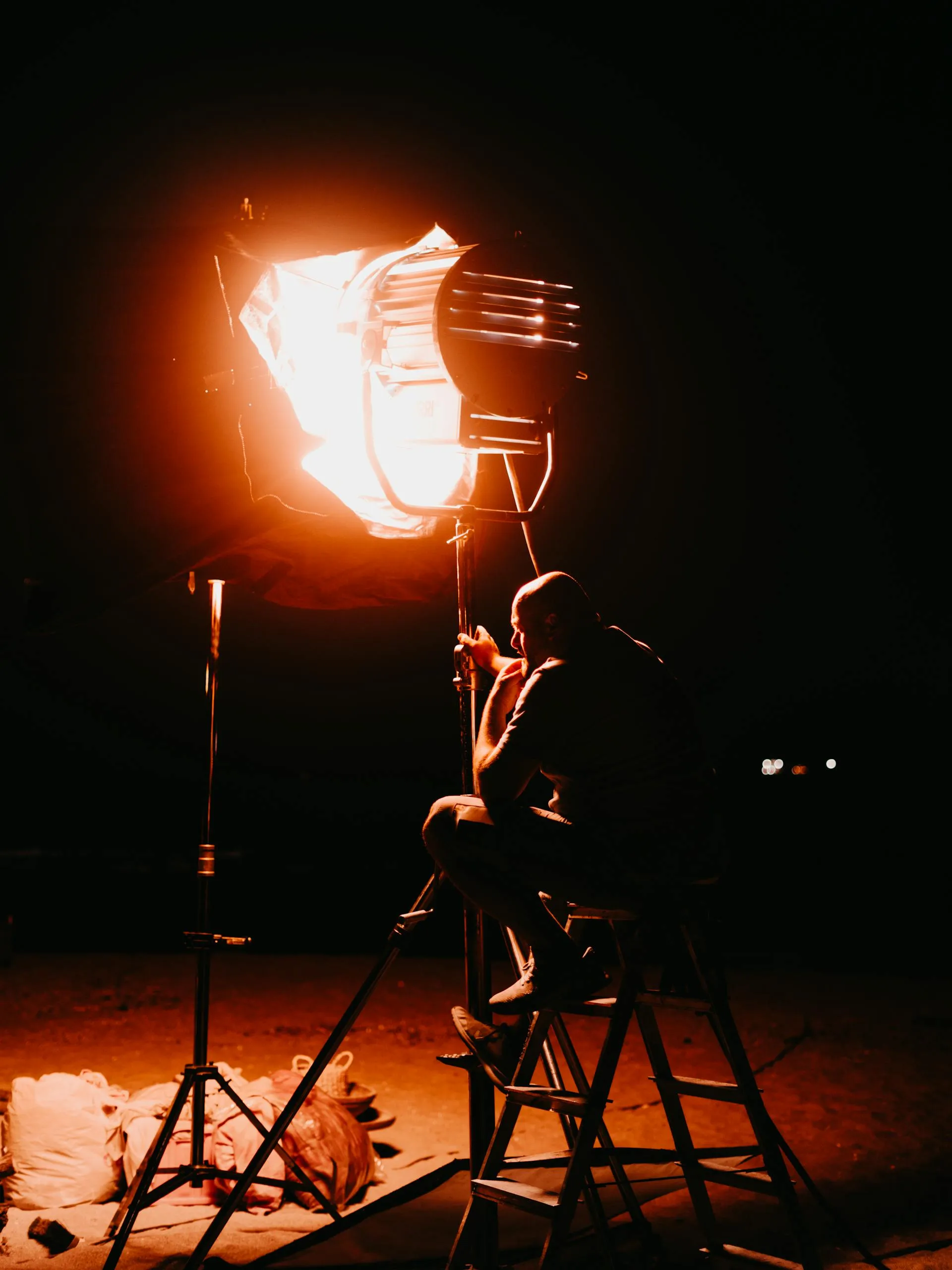 A director lit by a single studio light on set
