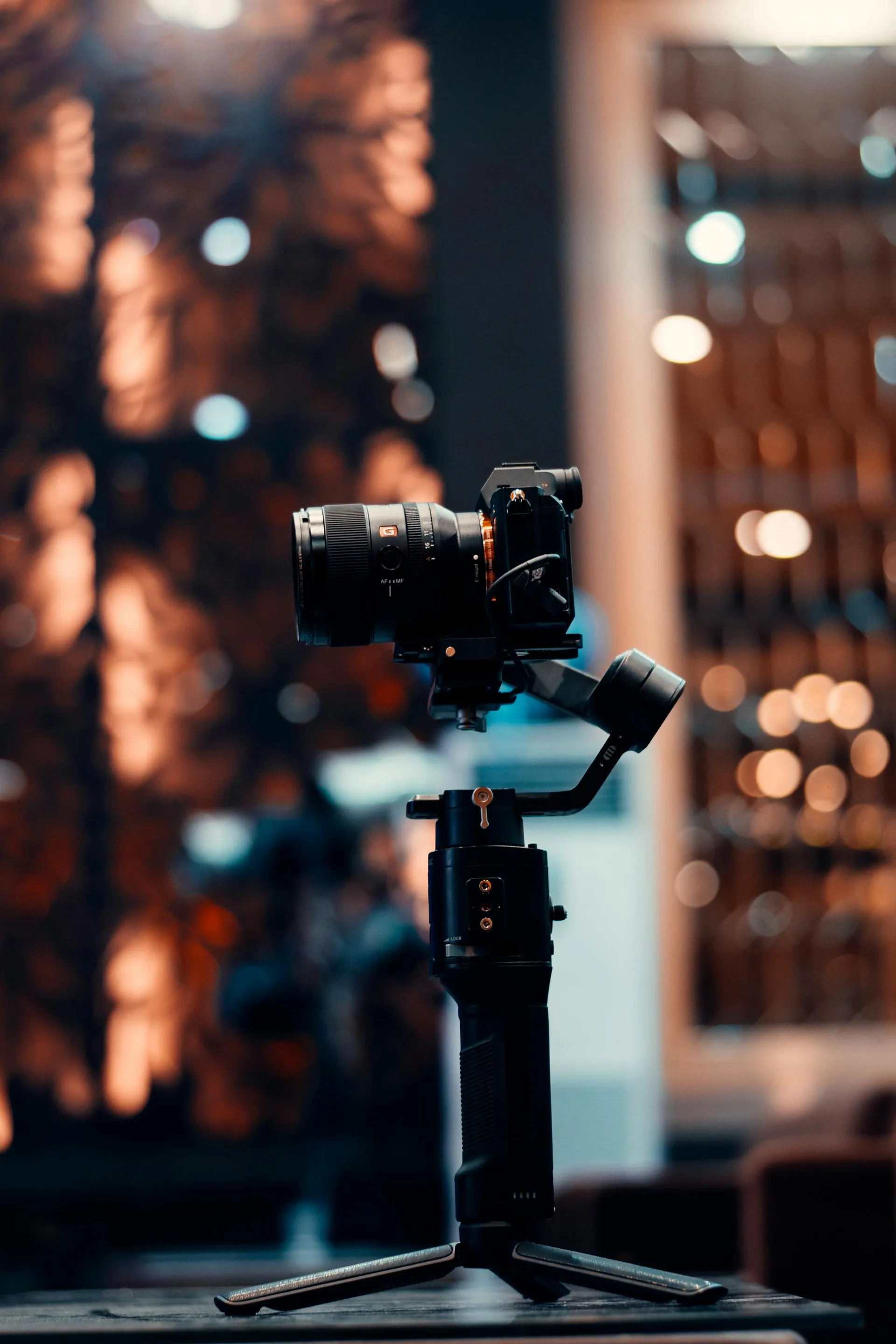 A camera on a gimbal rig inside a warmly lit studio space