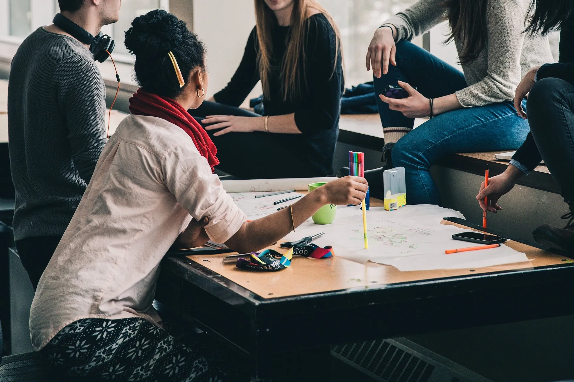 A small group of creators collaborating around a table during a hands-on workshop session